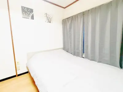 a bedroom with a white bed and a window at Nogata Relaxing Home D2 in Tokyo