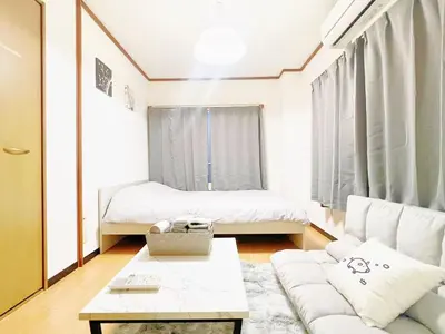 a living room with a couch and a bed at Nogata Relaxing Home D2 in Tokyo