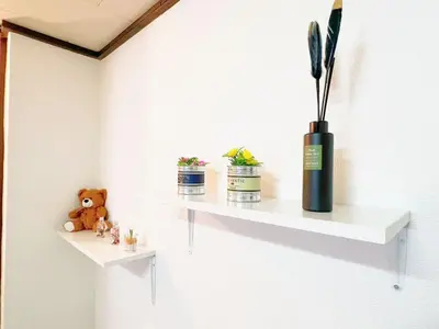 a white shelf with two potted plants and a vase at Nogata Relaxing Home D2 in Tokyo