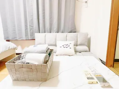 a living room with a couch and a remote control at Nogata Relaxing Home D2 in Tokyo