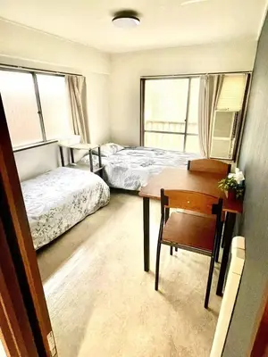 a bedroom with two beds and a desk and a table at Tokyo Shinjuku Nishi-Waseda House Station 2mins in Tokyo