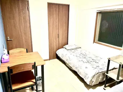 a room with a bed and a desk and a table at Tokyo Shinjuku Nishi-Waseda House Station 2mins in Tokyo