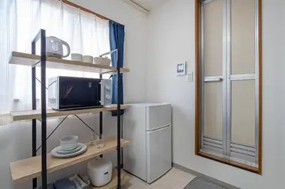a small kitchen with a microwave and a refrigerator at CraftFlat Numabukuro 301, uphill residence in Tokyo