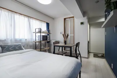 a bedroom with a bed and a table and a desk at CraftFlat Numabukuro 301, uphill residence in Tokyo