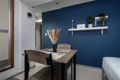 a dining room with a table and a blue wall at CraftFlat Numabukuro 301, uphill residence in Tokyo