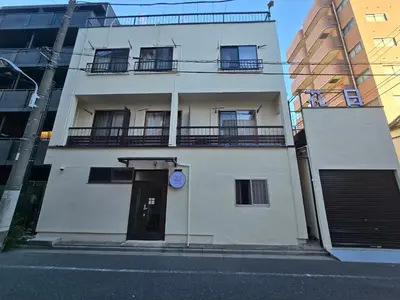 a white building with a door and a clock on it at \u6d45\u8349\u82b1\u65e5\u7f8e\u5c45 \u5c0f\u5c9b105\u6d45\u8349\u5bfa\u7d27\u90bb in Tokyo