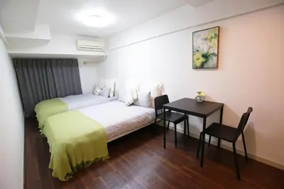 a hotel room with a bed and a table and chair at \u6b4c\u821e\u4f0e\u753a\u306e\u4e2d\u5fc3 \u30c9\u30f3\u30ad\u30db\u30fc\u30c6 \u4f0a\u52e2\u4e39\u65b0\u5bbf\u3078\u4fbf\u5229 \u89b3\u5149 \u30b7\u30e7\u30c3\u30d4\u30f3\u30b0 \u30b0\u30eb\u30e1\u304c\u5f92\u6b69\u570f\u306e\u90fd\u5e02\u578b\u5bbf QoSi in Tokyo