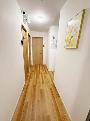 a hallway with white walls and a wooden floor at \u6d45\u8349\u82b1\u65e5\u7f8e\u5c45 Asakusa Hanahi 201 Queen Bed Room, 4 min walk to Asakusa Temple, direct subway access to Narita and Haneda Airport in Tokyo