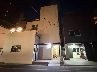 a building with a door on the side of it at night at \u6d45\u8349\u82b1\u65e5\u7f8e\u5c45 Asakusa Hanahi 201 Queen Bed Room, 4 min walk to Asakusa Temple, direct subway access to Narita and Haneda Airport in Tokyo