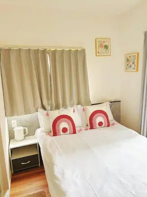 a bedroom with a bed with red and white pillows at \u6d45\u8349\u82b1\u65e5\u7f8e\u5c45 Asakusa Hanichi 202 Queen Bed Room, 4 min walk to Asakusa Temple, direct subway access to Narita and Haneda Airport in Tokyo