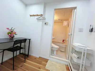 a bathroom with a toilet and a table and a mirror at \u6d45\u8349\u82b1\u65e5\u7f8e\u5c45 Asakusa Hanahi 305 Queen Bed Room, 4 min walk to Asakusa Temple, direct subway access to Narita and Haneda Airport in Tokyo