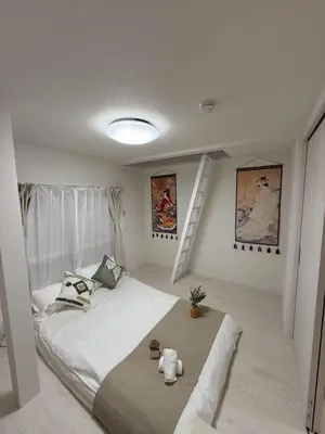 a white bedroom with a bed and a staircase at Sogno House Tokyo Ueno in Tokyo