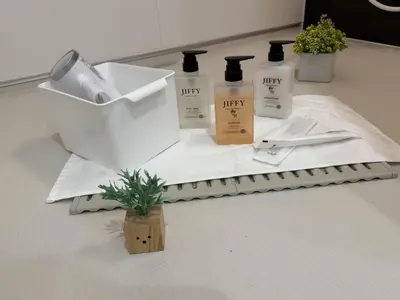 a bathroom counter with three bottles of unity products on a towel at Sogno House Tokyo Ueno in Tokyo
