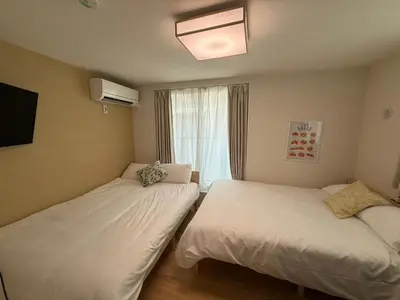 two beds in a room with a window at \u3055\u304f\u3089\u65c5\u9928\u9ad8\u5186\u5bfa\u5317\u5343\u5229\u4f11201\u53f7\u5ba4 in Tokyo