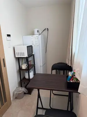 a small kitchen with a table and a refrigerator at \u3055\u304f\u3089\u65c5\u9928\u9ad8\u5186\u5bfa\u5317\u5343\u5229\u4f11201\u53f7\u5ba4 in Tokyo