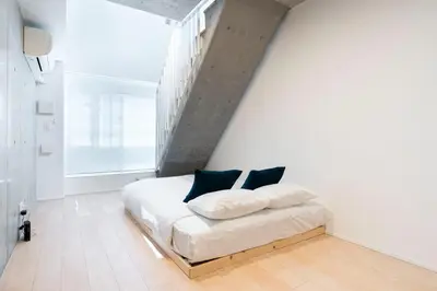 a bedroom with a white bed with blue pillows at PASEO\u5e02\u8c37\u53f0\u753al in Tokyo
