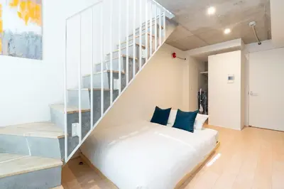 a bedroom with a white bed and a staircase at PASEO\u5e02\u8c37\u53f0\u753al in Tokyo