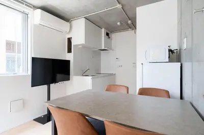 a kitchen with a table and chairs and a refrigerator at PASEO\u5e02\u8c37\u53f0\u753al in Tokyo