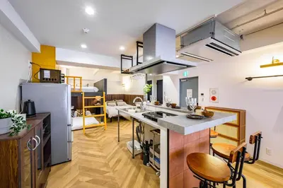 a kitchen and living room with a kitchen island in a room at TOMARU Meguro in Tokyo