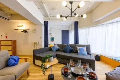 a living room with a couch and a table at TOMARU Meguro in Tokyo