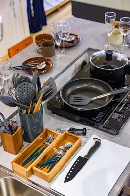 a kitchen counter with utensils and a pan on a stove at TOMARU Meguro in Tokyo