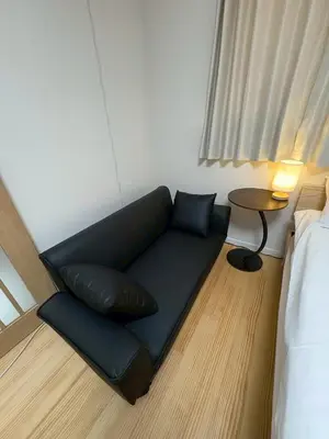 a couch in a room with a bed and a table at \u3055\u304f\u3089\u65c5\u9928\u9ad8\u5186\u5bfa\u5317\u5343\u5229\u4f11202\u53f7\u5ba4 in Tokyo