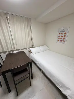 a small bedroom with a bed and a desk at \u3055\u304f\u3089\u65c5\u9928\u9ad8\u5186\u5bfa\u5317\u5343\u5229\u4f11202\u53f7\u5ba4 in Tokyo