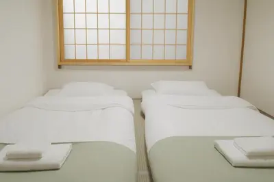 three beds in a room with white walls at \u5317\u533a\u99d2\u8fbc\u99c5 \u8fd1\u30a2\u30d1\u30fc\u30c8 \u6700\u592710\u540dstay OK in Tokyo