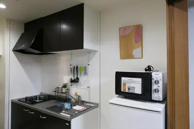 a kitchen with a sink and a microwave and a refrigerator at M106 Easy access to Ikebukuro Red Leaves in Tokyo
