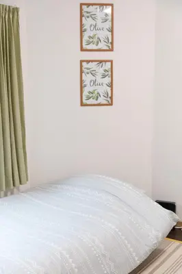 a bed with white sheets and a picture on the wall at Yoshiya in Tokyo