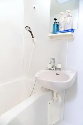 a white bathroom with a sink and a shower at Yoshiya in Tokyo