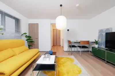 a living room with a yellow couch and a table at \u5bc5\u30db\u30c6\u30eb\u65b0\u6c5f\u53e4\u7530TORA HOTELShinEkoda in Tokyo