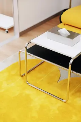 a white coffee table with a yellow chair on a rug at \u5bc5\u30db\u30c6\u30eb\u65b0\u6c5f\u53e4\u7530TORA HOTELShinEkoda in Tokyo