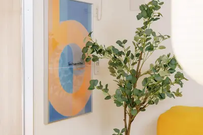a picture hanging on a wall next to a plant at \u5bc5\u30db\u30c6\u30eb\u65b0\u6c5f\u53e4\u7530TORA HOTELShinEkoda in Tokyo