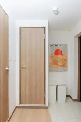 a bathroom with a wooden door and two trash cans at \u5bc5\u30db\u30c6\u30eb\u65b0\u6c5f\u53e4\u7530TORA HOTELShinEkoda in Tokyo