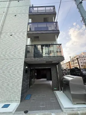a tall building with a walkway in front of it at \u5bc5\u30db\u30c6\u30eb\u65b0\u6c5f\u53e4\u7530TORA HOTELShinEkoda in Tokyo