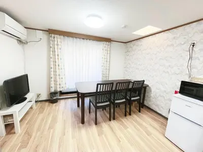 a dining room with a table and chairs and a television at Shinjuku Homely House 4Rooms-D in Tokyo