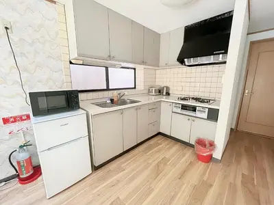 a kitchen with white cabinets and a wooden floor at Shinjuku Homely House 4Rooms-D in Tokyo