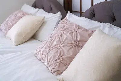 a bed with white pillows and a pink comforter at Omo-Yado 20 minutes by car from Haneda Entire house in Tokyo