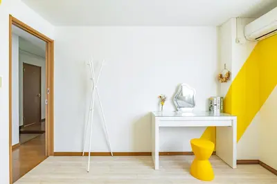 a room with a white table and a yellow stool at \u65b0\u5bbf\u6e0b\u8c37\u8fd1\u304f\u306b\u3042\u308b3\u5bdd\u5ba4105\u5e73\u7c73\u306e\u30a2\u30d1\u30fc\u30c8\u30e1\u30f3\u30c8 in Tokyo