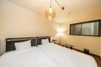 a bedroom with a large bed with white sheets at Wooden house max 8 people 7 minutes walk to Skytree 75 square meters in Tokyo