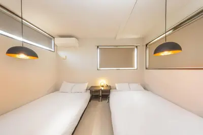 two beds in a room with a table and two lights at Wooden house max 8 people 7 minutes walk to Skytree 75 square meters in Tokyo