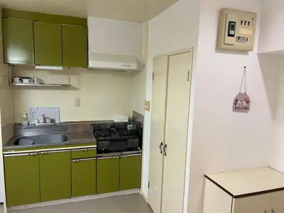 a small kitchen with green cabinets and a sink at Ikebukuro\u4e2d\u5ddd4D-TS0035 in Tokyo