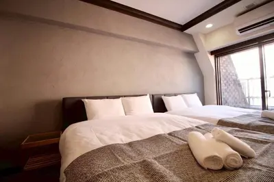 a bedroom with two beds with white sheets and a window at Sun Mall Crest 506 - Vacation STAY 19930 in Tokyo