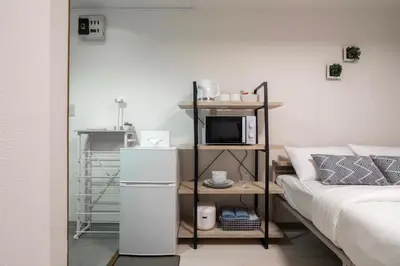 a living room with a bed and a microwave oven at CraftFlat Numabukuro 302, uphill residence in Tokyo