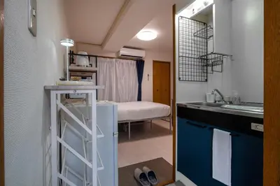 a bathroom with a sink and a room with a bed at CraftFlat Numabukuro 302, uphill residence in Tokyo