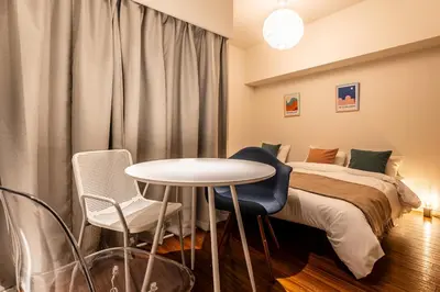 a bedroom with a bed and a table and chairs at \u30ec\u30b8\u30c7\u30f3\u30b7\u30e3\u30eb\u30b9\u30c6\u30fc\u30b8405 in Tokyo