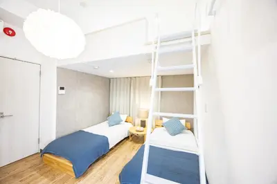 a bedroom with two beds and a ladder at Sugamo hotel 2F-TS0335 in Tokyo