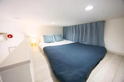 a bedroom with a large bed with a blue blanket at Sugamo hotel 2F-TS0335 in Tokyo