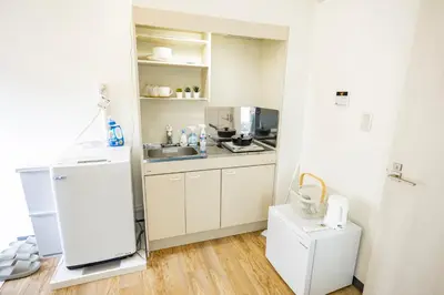 a small kitchen with a refrigerator and a sink at Sugamo hotel 2F-TS0335 in Tokyo
